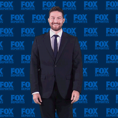 Man In Suit And Tie In Front Of Fox Deportes Background GIF