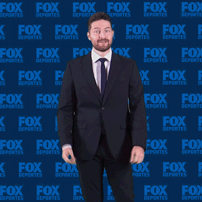 Man In Suit And Tie In Front Of Fox Deportes Background GIF
