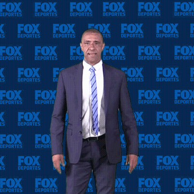 Man In Suit And Tie In Front Of Fox Deportes Wall GIF