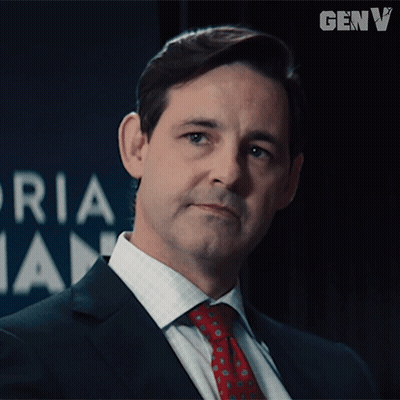 Man In Suit And Tie In Front Of Genv Logo GIF