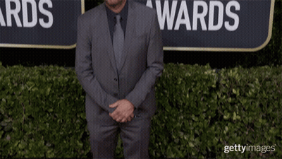 Man In Suit And Tie In Front Of Globe Awards Sign GIF