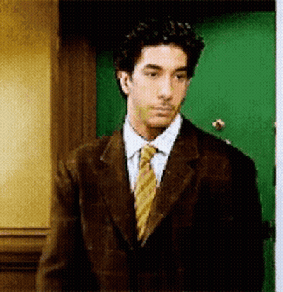 Man in Suit and Tie in Front of Green Door