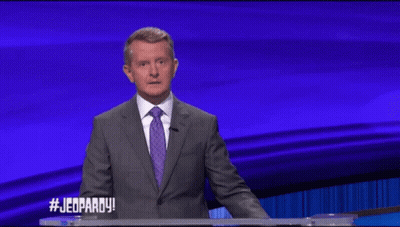 Man In Suit And Tie In Front Of Jeopardy Screen GIF