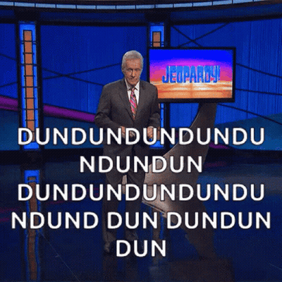 Man In Suit And Tie In Front Of Jeopardy Screen GIF