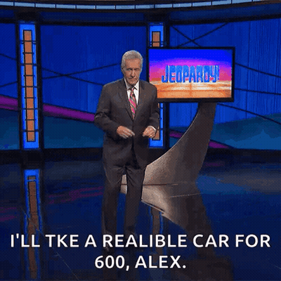 Man In Suit And Tie In Front Of Jeopardy Screen GIF