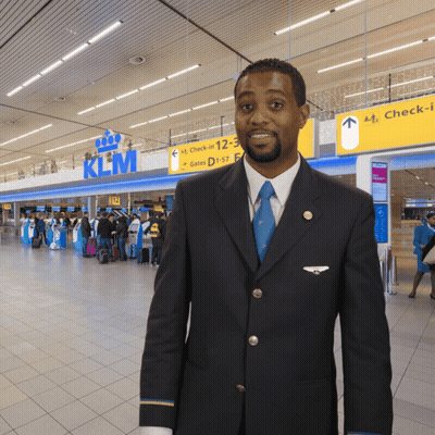 Man In Suit And Tie In Front Of KLM Sign GIF