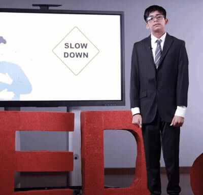 Man In Suit And Tie In Front Of Large TED Sign GIF