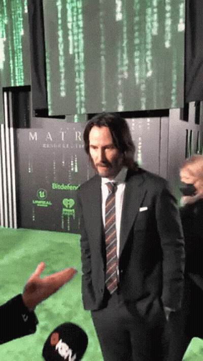 Man In Suit And Tie In Front Of Matrix Sign GIF