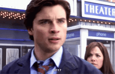 Man In Suit And Tie In Front Of Theater Sign GIF