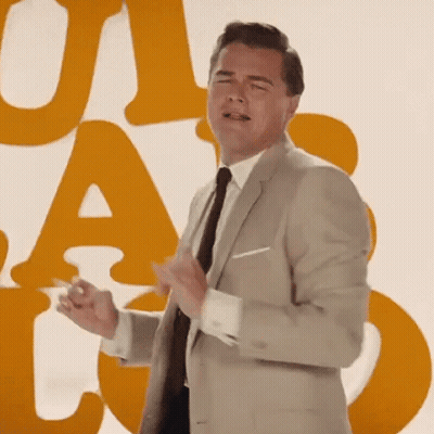 Man In Suit And Tie In Front Of UA And T Wall GIF