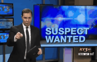 Man In Suit And Tie In Front Of Wanted Sign GIF