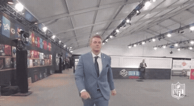 Man In Suit And Tie In Room With NFL Logo GIF