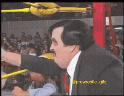 Man In Suit And Tie In Wrestling Ring Arm Outstretched GIF