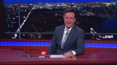 Man In Suit And Tie Laughing At Desk GIF