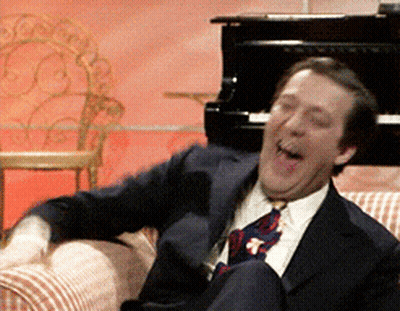 Man In Suit And Tie Laughing At Piano GIF