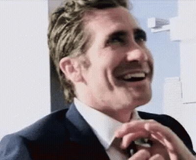 Man In Suit And Tie Laughing Hands In Pockets GIF