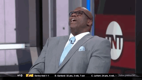 Man In Suit And Tie Laughing In Front Of TNT Logo GIF