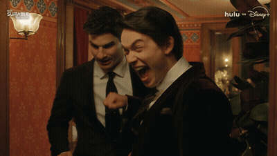 Man In Suit And Tie Laughing In Hallway Hulu On Disney+ GIF