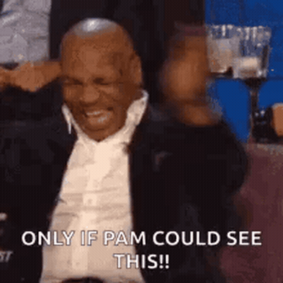 Man In Suit And Tie Laughing In Stadium GIF