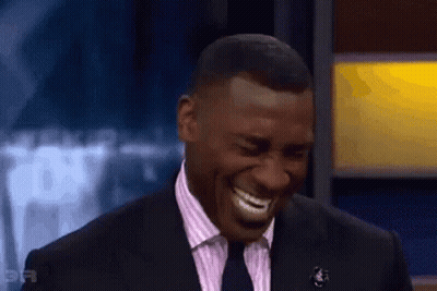 Man In Suit And Tie Laughing On Stage GIF