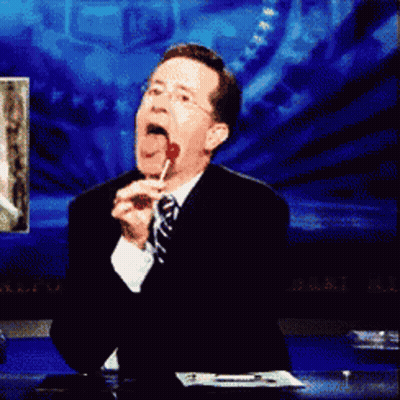 Man In Suit And Tie Licking Red Lollipop GIF