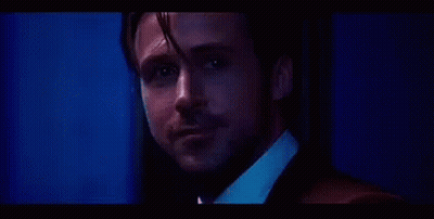 Man In Suit And Tie Looking At Camera Blue Background GIF