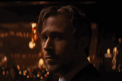 Man In Suit And Tie Looking At Camera In Dark Room GIF