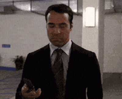 Man In Suit And Tie Looking At Phone GIF