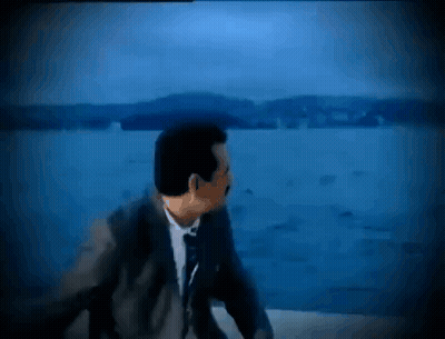 Man In Suit And Tie Looking Over Water GIF