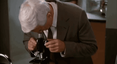 Man In Suit And Tie Looking Through Microscope In Lab GIF
