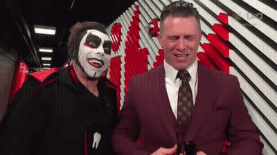 Man In Suit And Tie Next To Clown Mask GIF