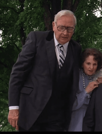 Man In Suit And Tie Next To Woman With Pearls GIF