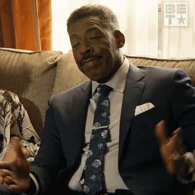 Man in Suit and Tie on Couch With BET Logo