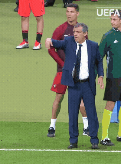 Man In Suit And Tie On Soccer Field With UEFA Logo GIF
