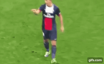 Man In Suit And Tie On Soccer Field With UEFA Logo GIF