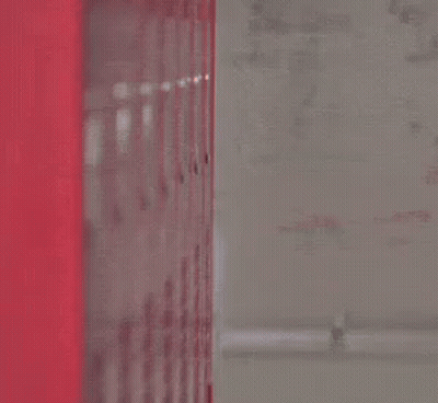 Man In Suit And Tie Peeking From Red Locker GIF