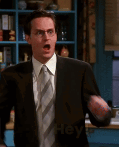 Man In Suit And Tie Pointing At Camera Saying Hey GIF
