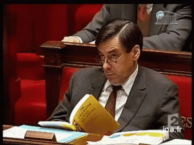 Man In Suit And Tie Reading En Masse GIF