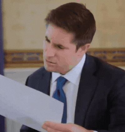 Man In Suit And Tie Reading Paper GIF