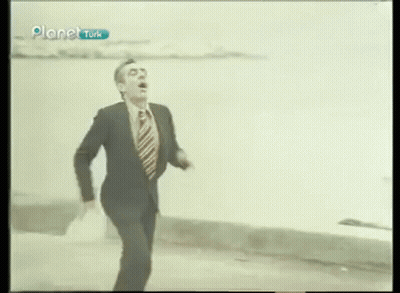 Man In Suit And Tie Running Across Street GIF