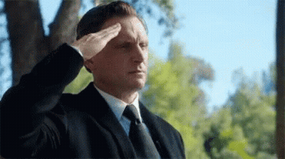 Man In Suit And Tie Saluting By Tree GIF