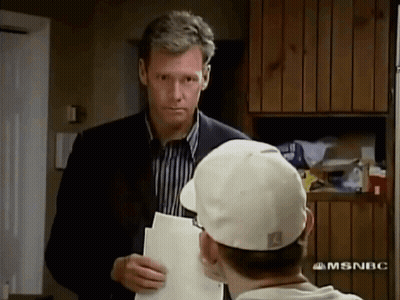 Man In Suit And Tie Saying Have A Seat GIF