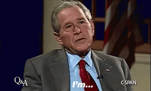 Man In Suit And Tie Saying Im In Front Of American Flag GIF
