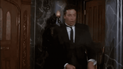 Man In Suit And Tie Says Oh Good Shot Green In Front Of Statue GIF