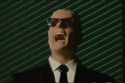 Man In Suit And Tie Screaming Into Mic With Sunglasses GIF