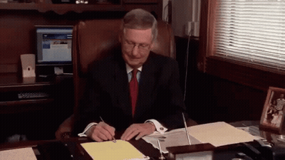 Man In Suit And Tie Signing Papers GIF