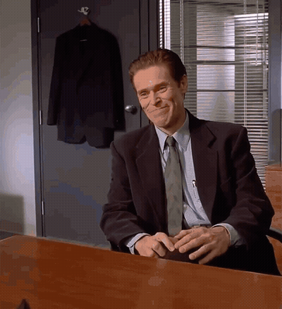 Man In Suit And Tie Sitting At Desk With Hands Folded GIF