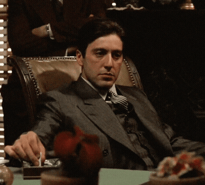 Man In Suit And Tie Sitting At Table GIF