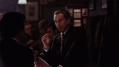 Man In Suit And Tie Sitting At Table GIF