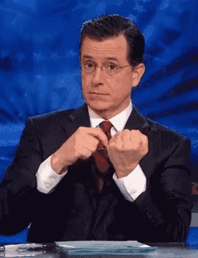 Man In Suit And Tie Sitting At Table GIF